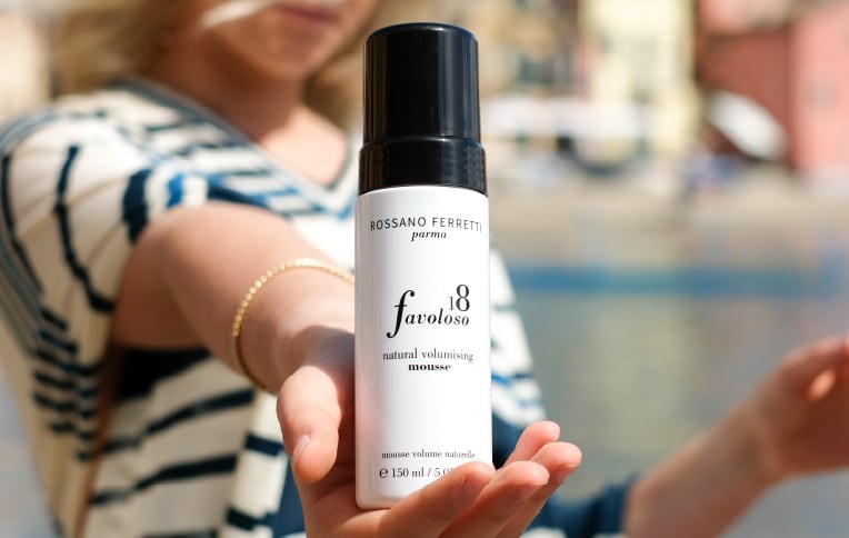 Image of a girl holding Rossano Ferretti Parma's Favoloso volumizing mousse.