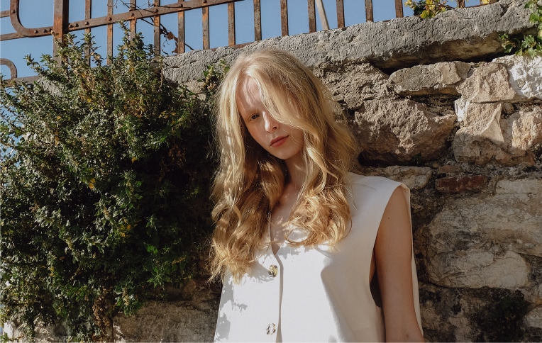 Immagine di una ragazza dai capelli biondi, mossi di media lunghezza, voluminosi.