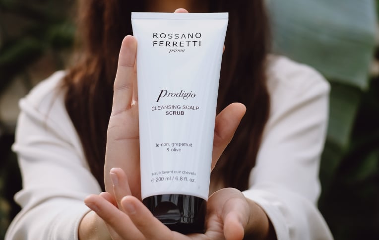 Image of a model holding Rossano Ferretti Parma's Prodigio cleansing scalp scrub.