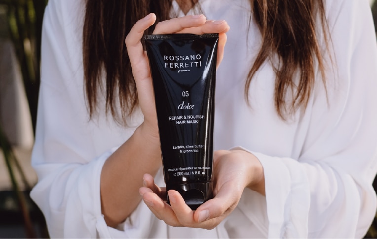 image of a girl holding Rossano Ferretti Parma's Nourishing hair mask Dolce