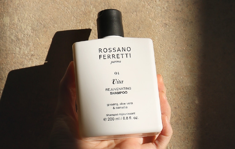 Immagine di una modella che tiene in mano lo shampoo rivitalizzante Vita di Rossano Ferretti Parma.