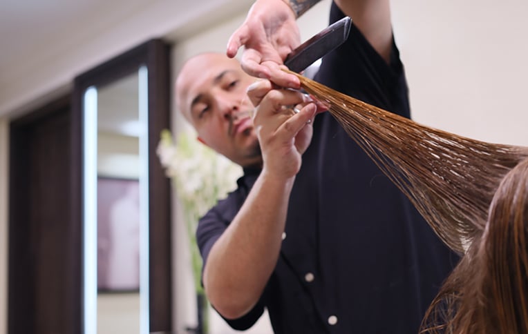 A hairstylist cutting a girl's hair.