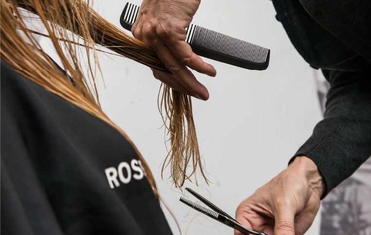 Image of a man cutting a woman's hair.