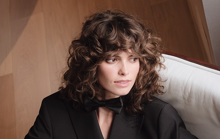 Image of a brunette girl with short, curly hair.