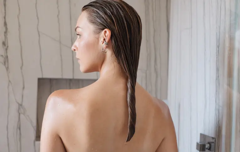 Woman with damp hair applying a luxurious Rossano Ferretti Parma treatment
