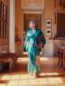 Blonde girl with a bob haircut wearing a long green floral dress