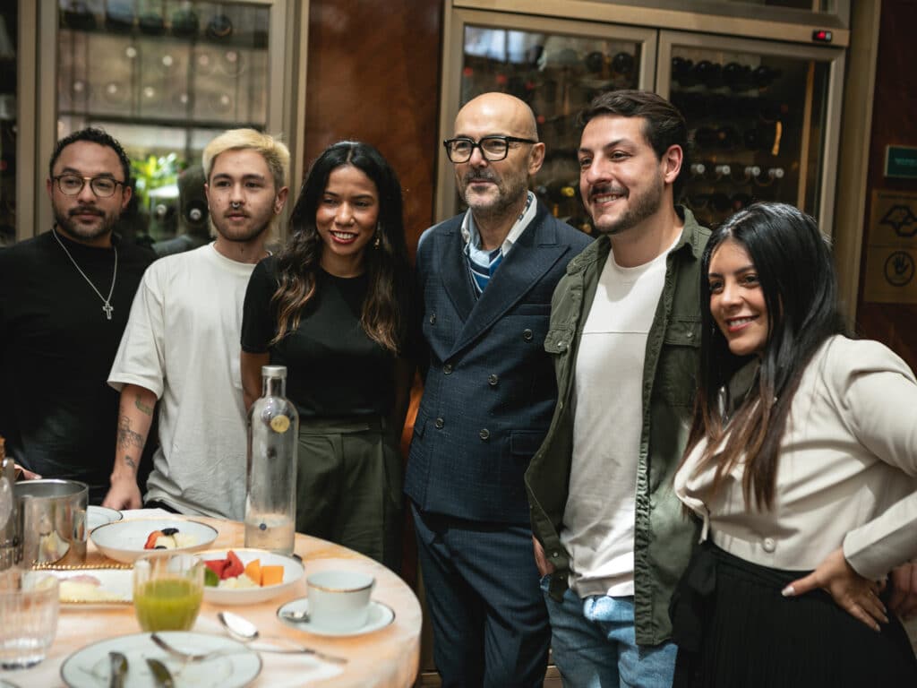 An image of Rossano Ferretti in a group photo with other people, all smiling.