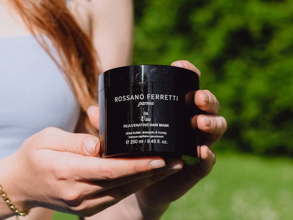 Image of a girl showing the Vita rejuvenating mask by Rossano Ferretti Parma in her hands. 