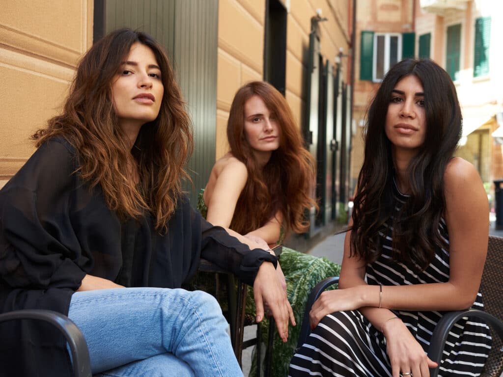 Image with three girls close to each other, each with different hairstyles.