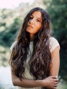 Image of a girl with long, wavy dark hair.