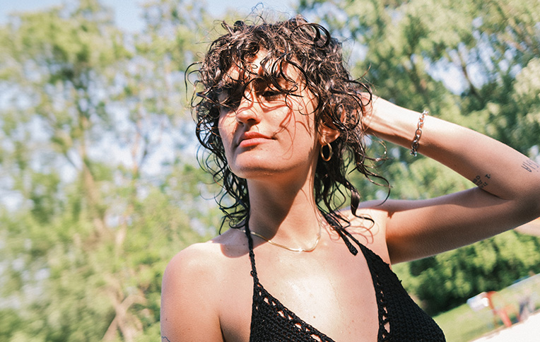 A girl with short curly hair enjoying the sun.