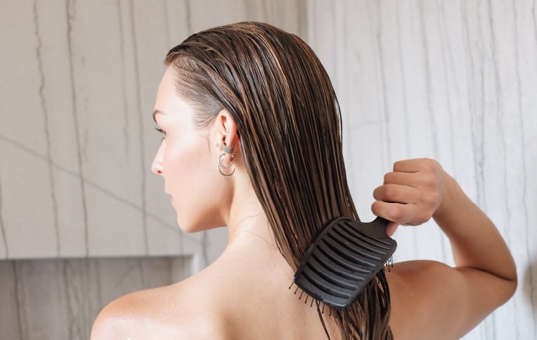 Image of a girl brushing her wet hair.