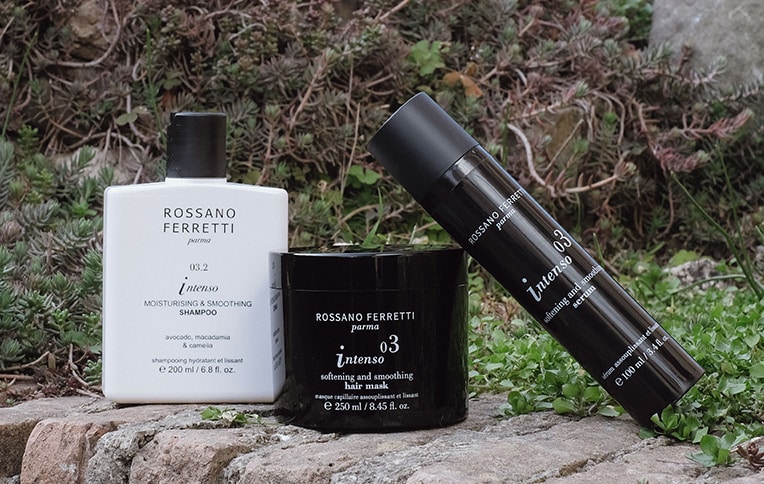 Image of the Intenso moisturising and smoothing shampoo, mask, and serum by Rossano Ferretti Parma, set against a background of plants and nature.