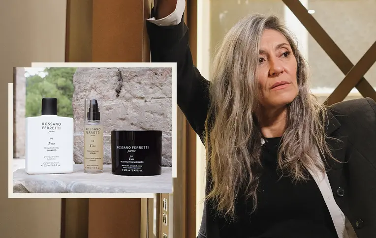 mature woman with long grey hair with the products from the Vita line by Rossano Ferretti Parma. Shampoo, mask, and Vita rejuvenating serum.
