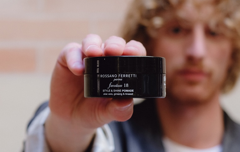 Image of a men holding Rossano Ferretti Parma's Favoloso style & shine pomade.