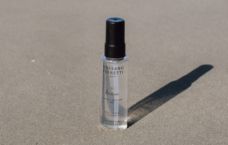 Rossano Ferretti Parma's Brillante protect and shine oil resting on the sand.
