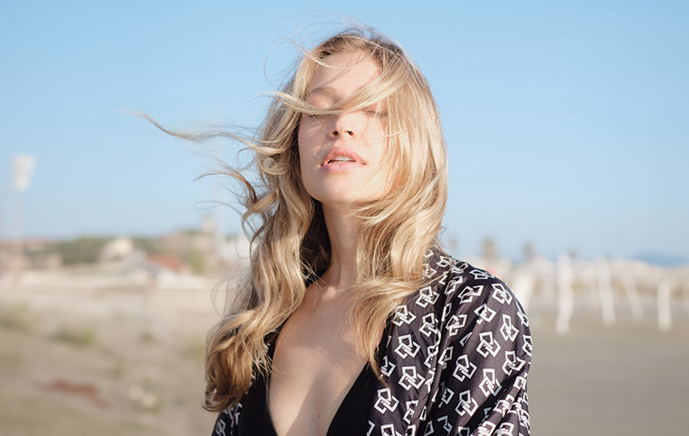 Girl with shiny, wavy blonde hair at the beach