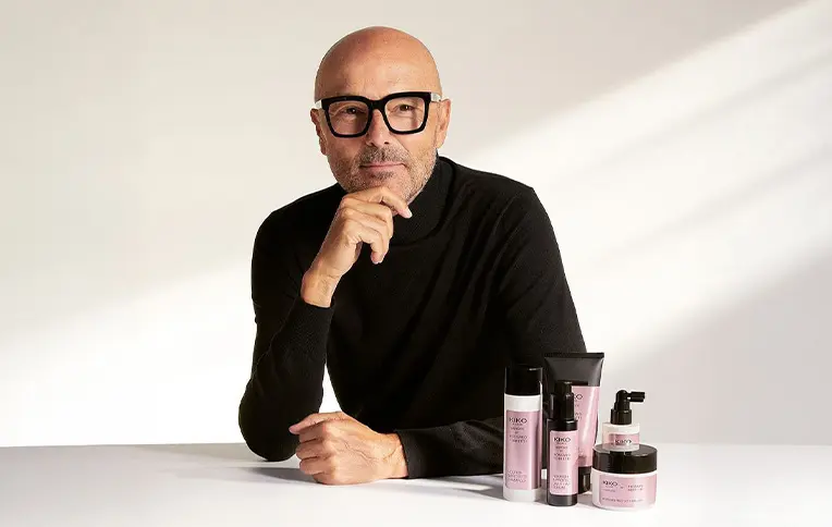 Rossano Ferretti standing next to the haircare range in collaboration with Kiko Milano makeup