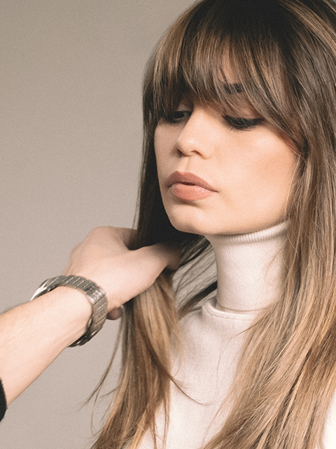 Image of a brunette girl with long, straight hair and curtain bangs.