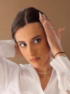 Woman adjusting her hair in front of a mirror.