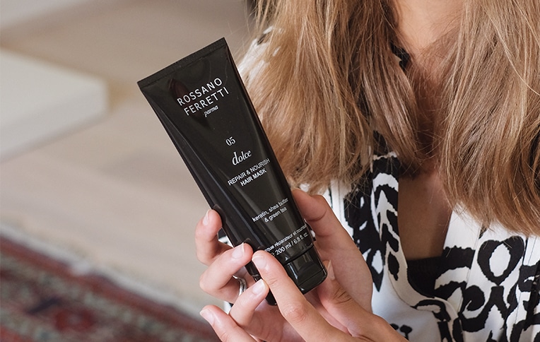 Image of a girl holding Rossano Ferretti Parma's repair and nourish hair mask from the Dolce line.